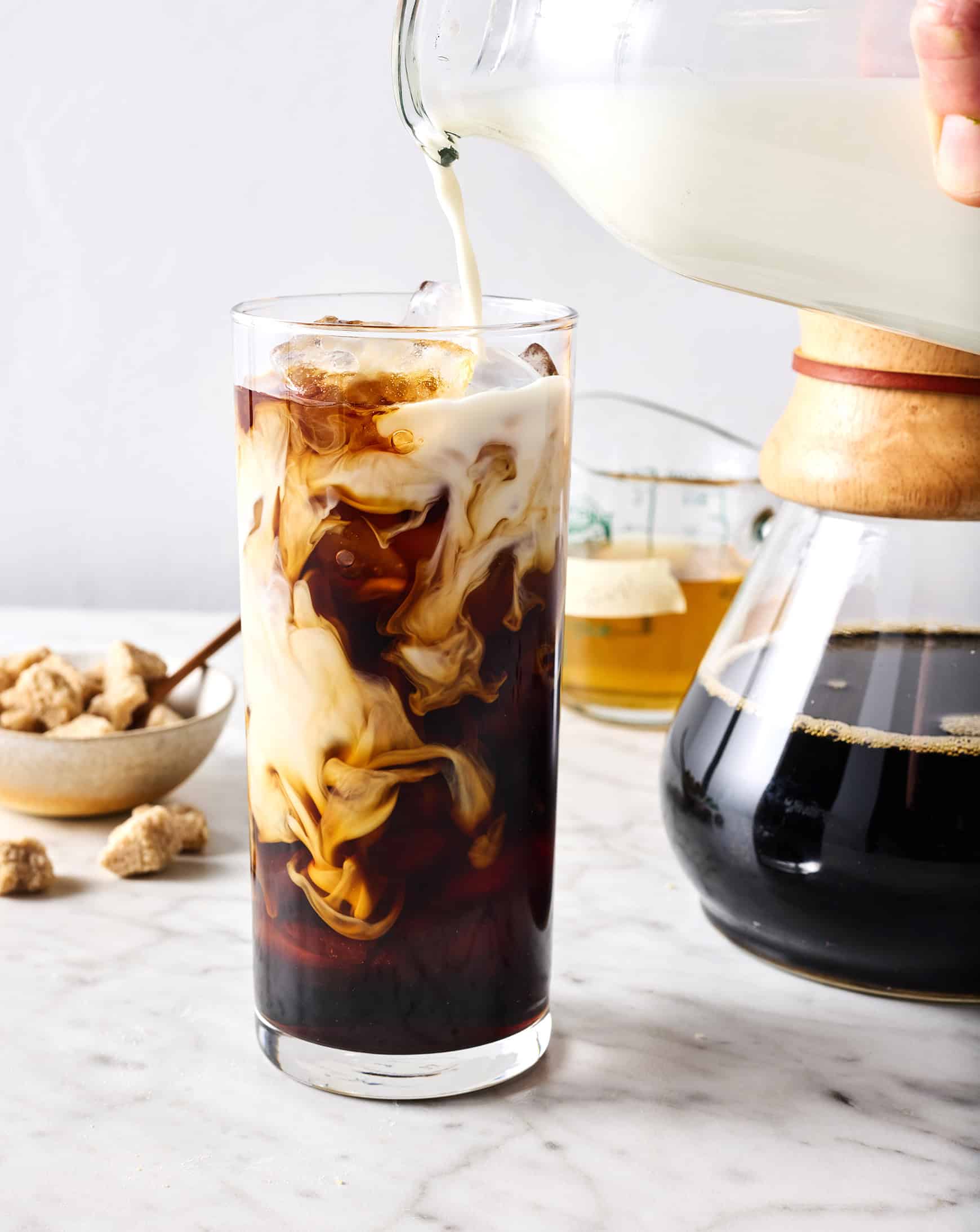 Pouring milk into iced coffee